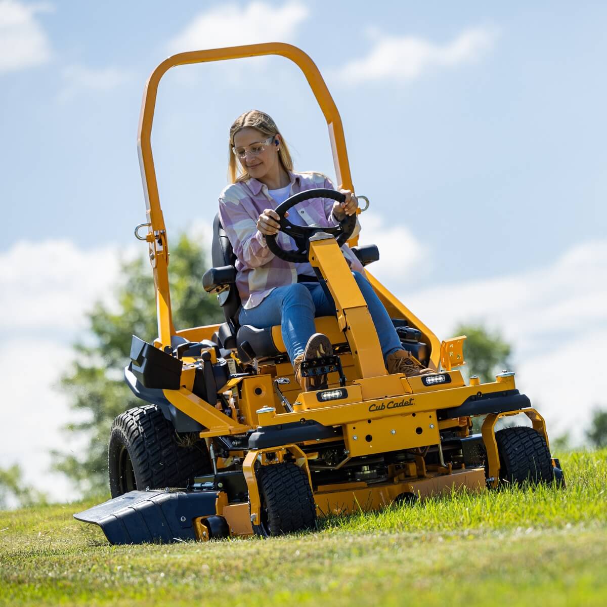 Woman mowing her property with a Cub Cadet ZTXS5 with ROPS.