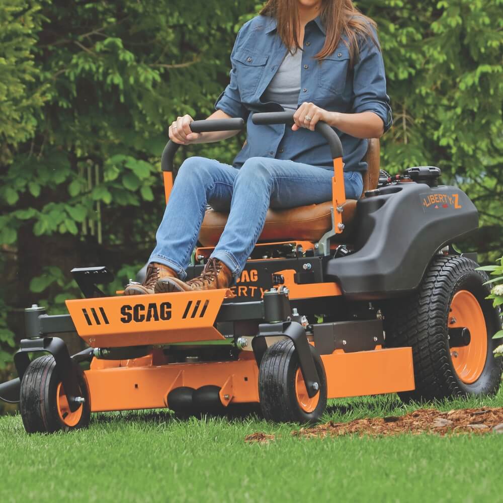 Load video: Woman wearing sunglasses operating the SCAG Liberty Z ride on mower