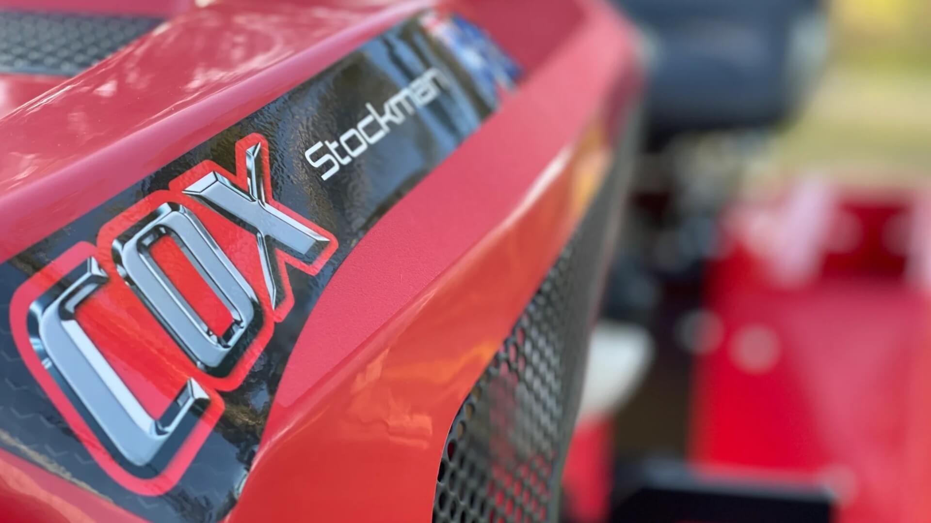 Close up angle looking down the side of the red Stockman ride on mower by Cox.