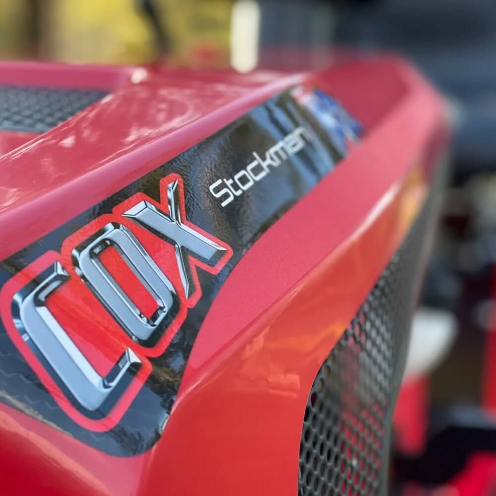 Red vehicle with 'Cox Stockman' logo on a blurred background.