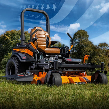 Orange and black SCAG Cheetah riding lawn mower on grass with a blue sky and trees in the background