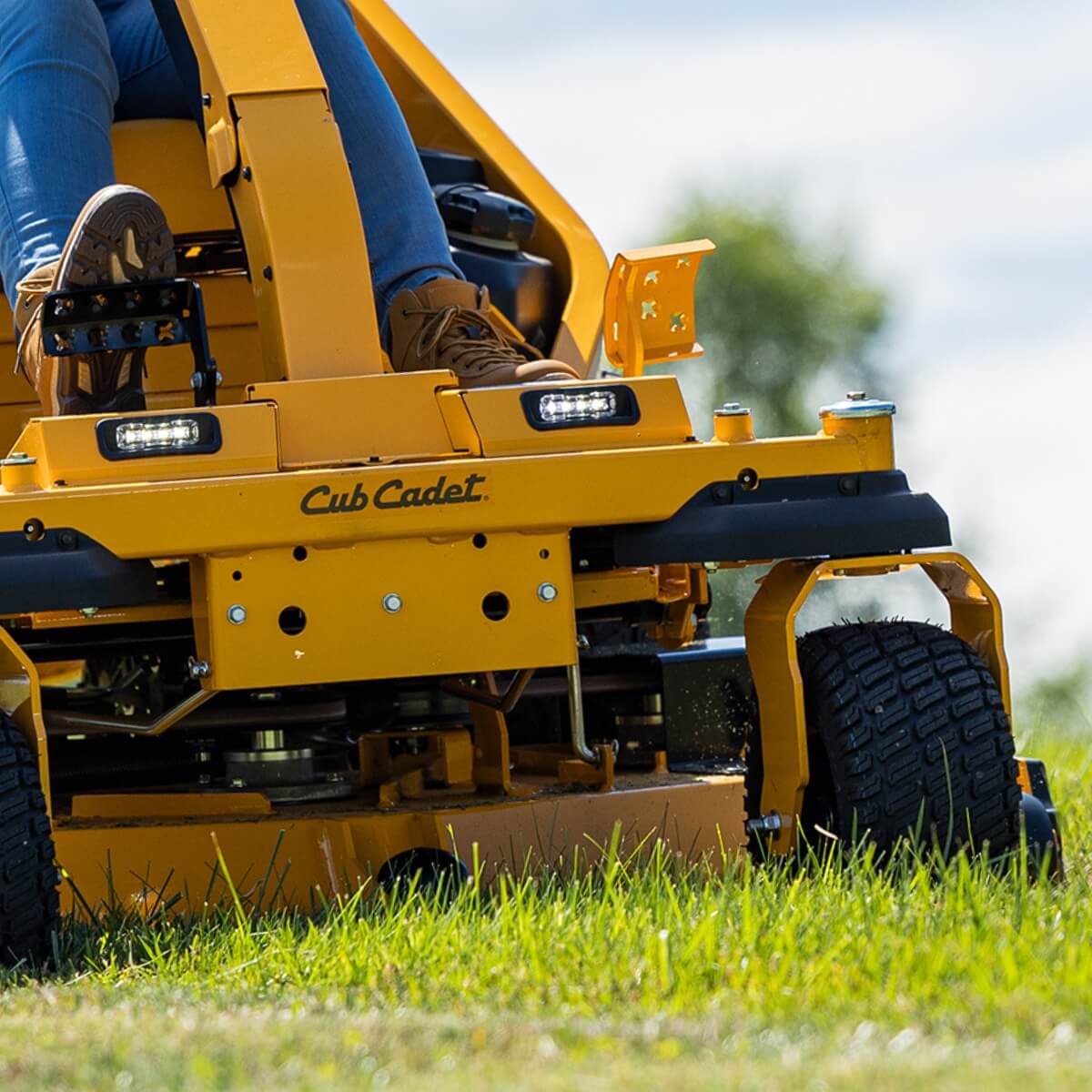 Close up low angle view of the Cub Cadet ZTXS5 ride on mower cutting long grass.