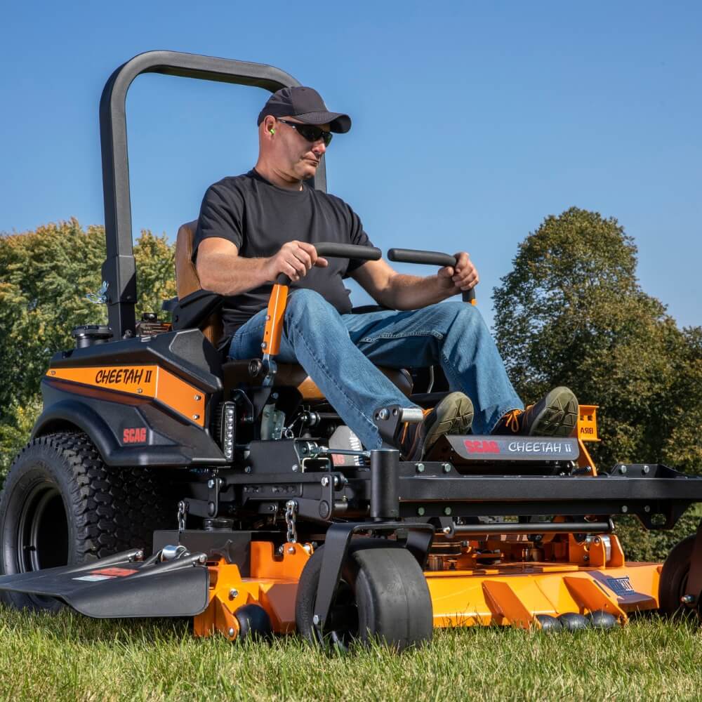 Man operating a Cheetah lawn mower on a sunny day
