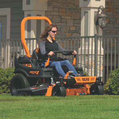 Woman operating a SCAG riding lawn mower in a residential yard.