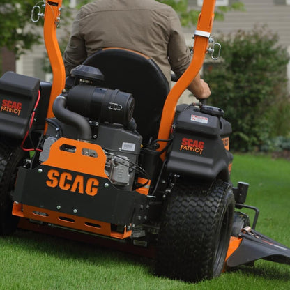 Person operating a SCAG Patriot zero-turn lawn mower on grass