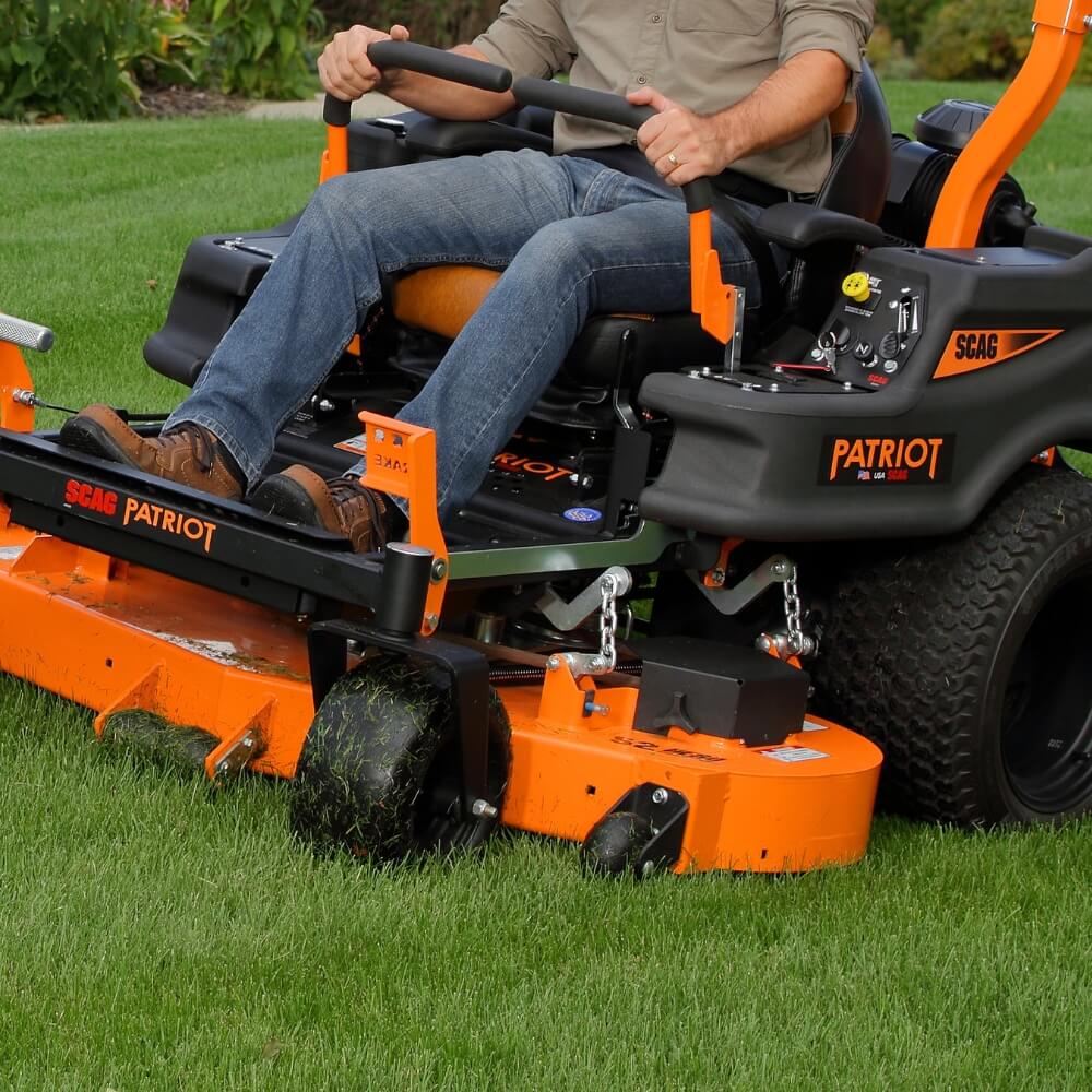 Person operating a SCAG Patriot riding lawn mower on grass