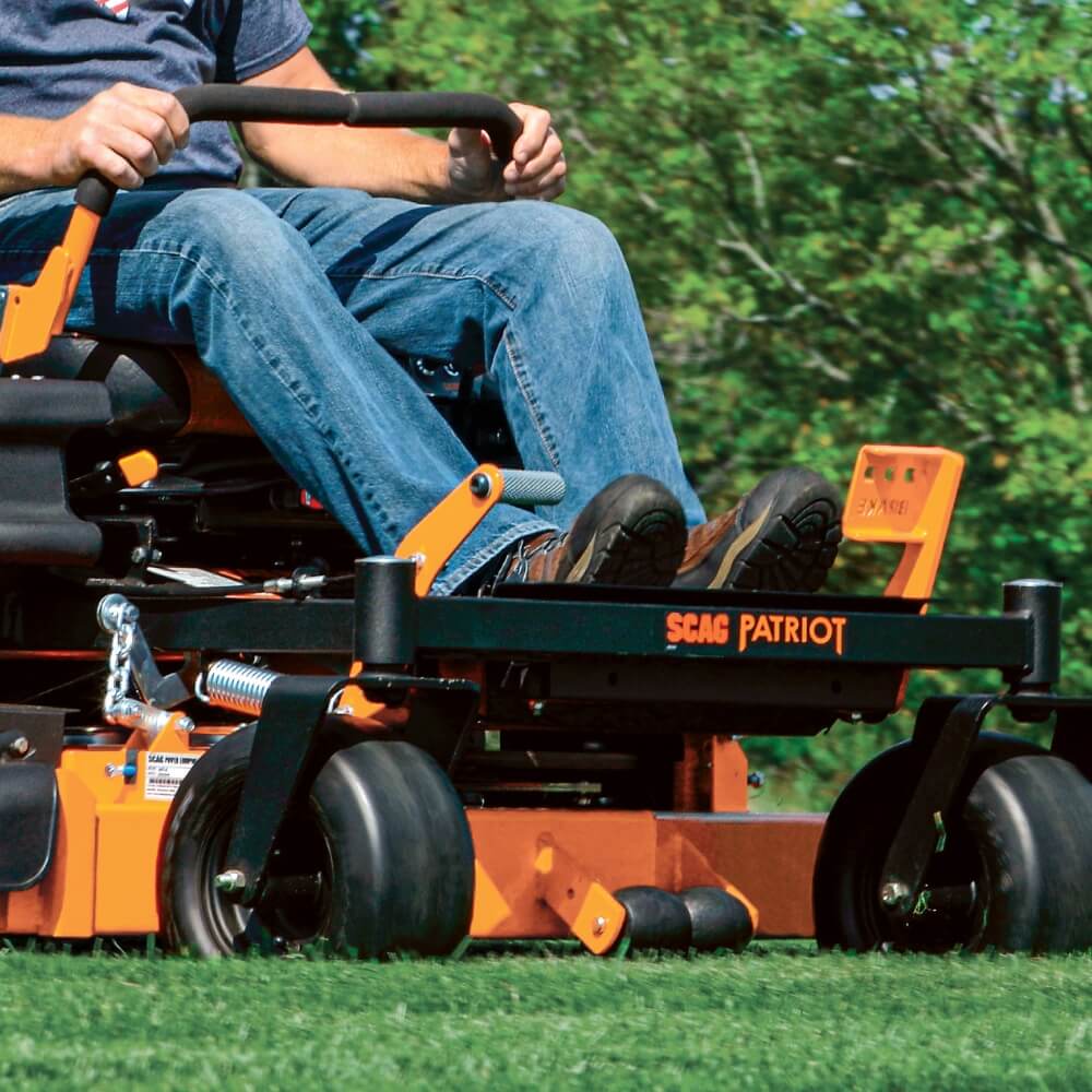 Person operating a Sears Patriot riding lawn mower on grass