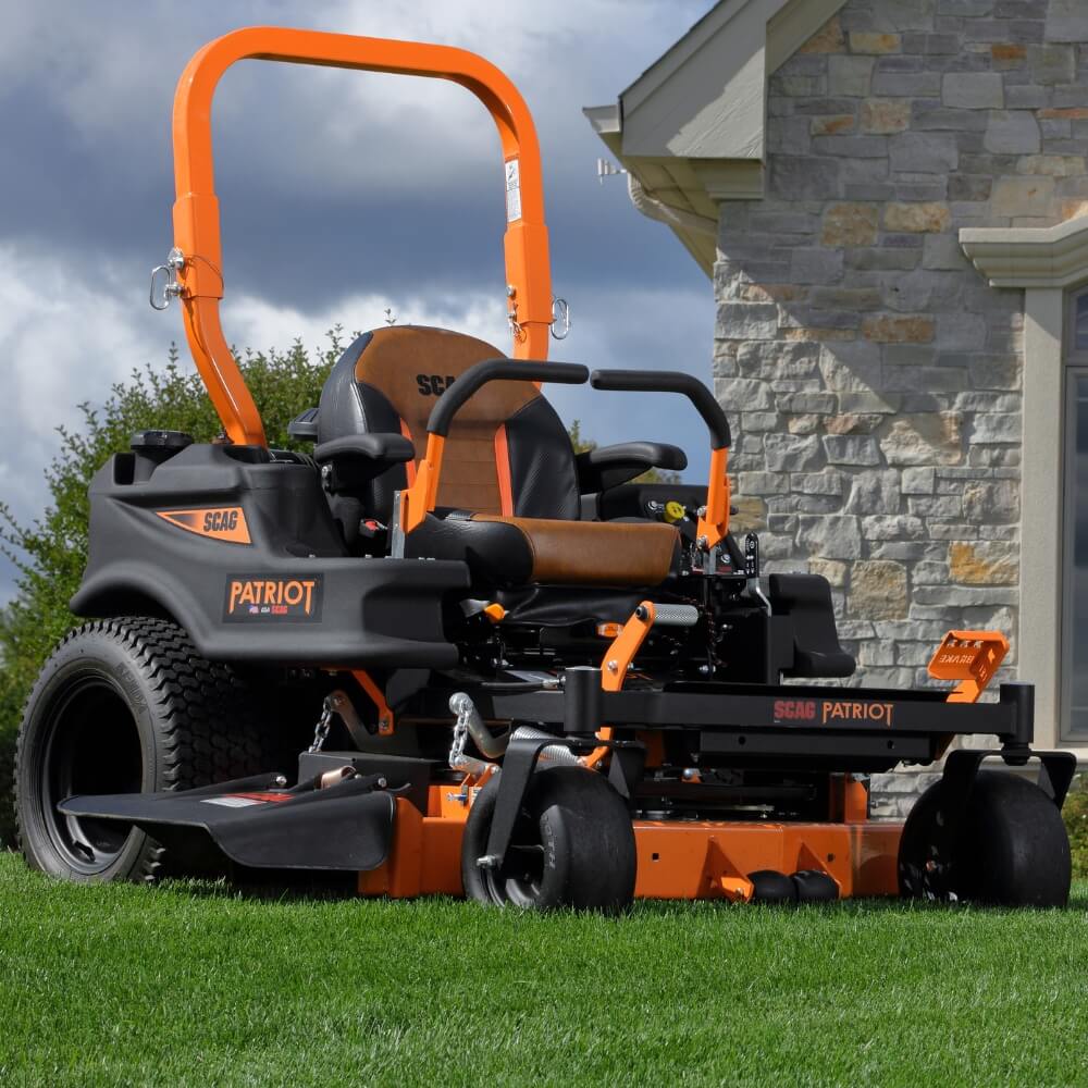 Scag Patriot zero-turn lawn mower on a grassy area with a stone building in the background