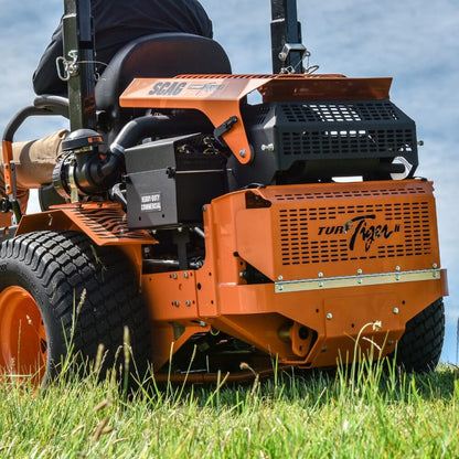 Orange SCAG mower in use on a grassy area in New Zealand with a clear sky.