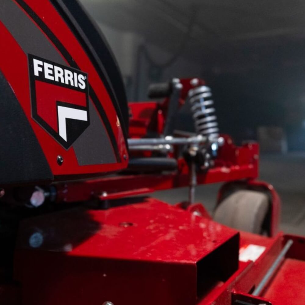 Red ride on mower with 'FERRIS' branding in a blurred indoor setting