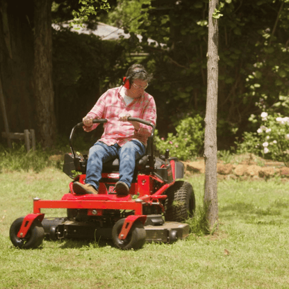 Man operating a red riding lawn mower in a garden setting